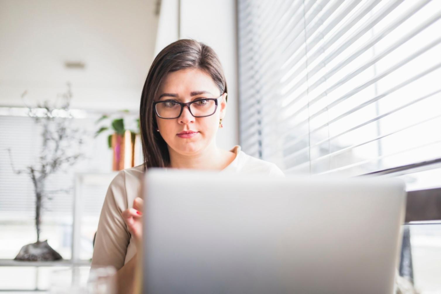 Étudiant planifiant ses finances mensuelles avec documents et ordinateur